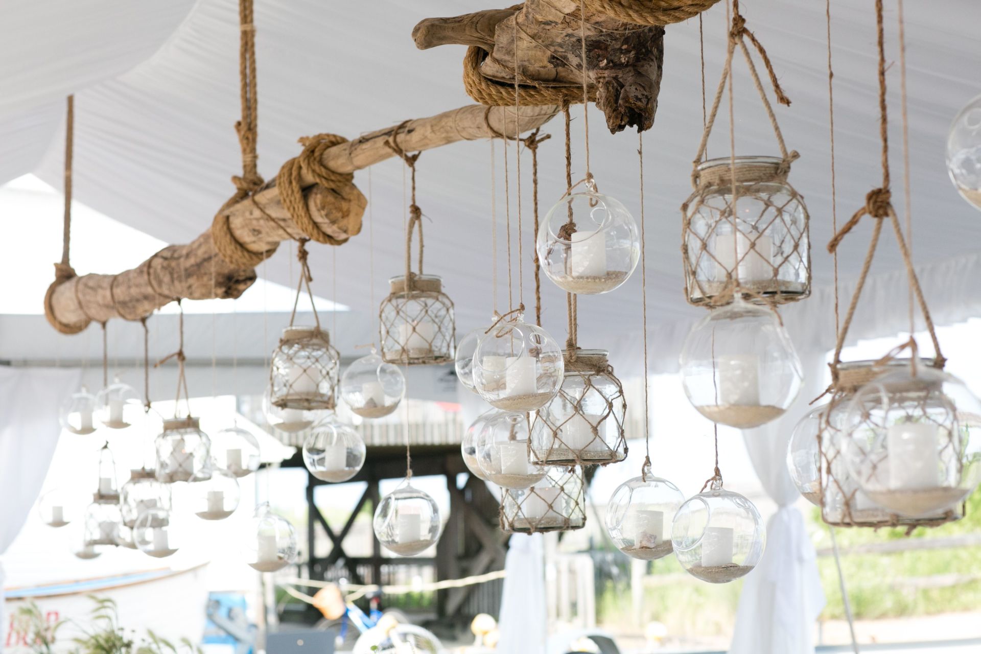 A bunch of candles are hanging from the ceiling of a tent