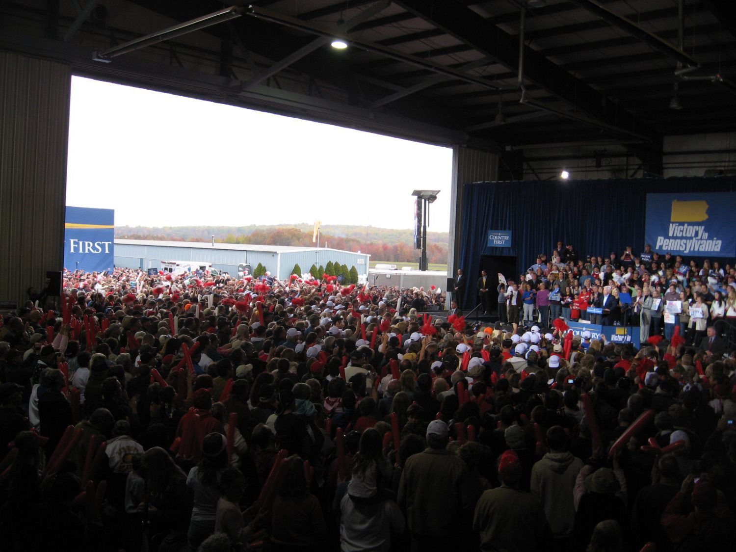 A large crowd is gathered in front of a stage that says first