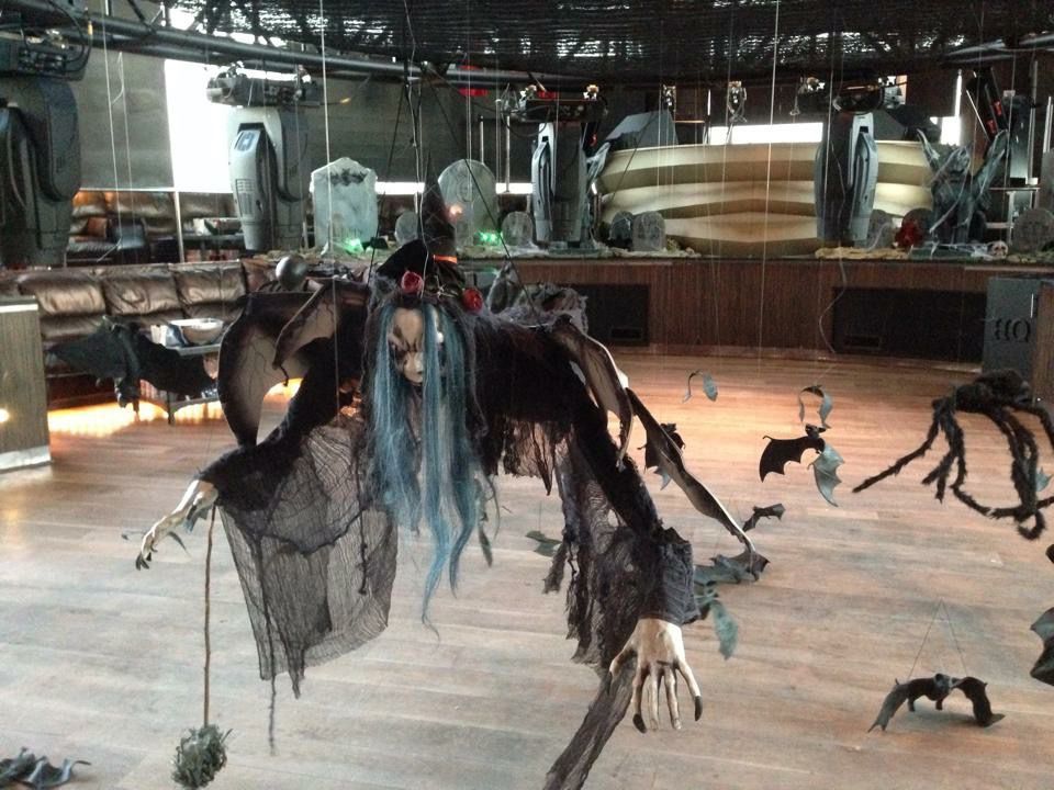 A witch with blue hair is hanging from the ceiling