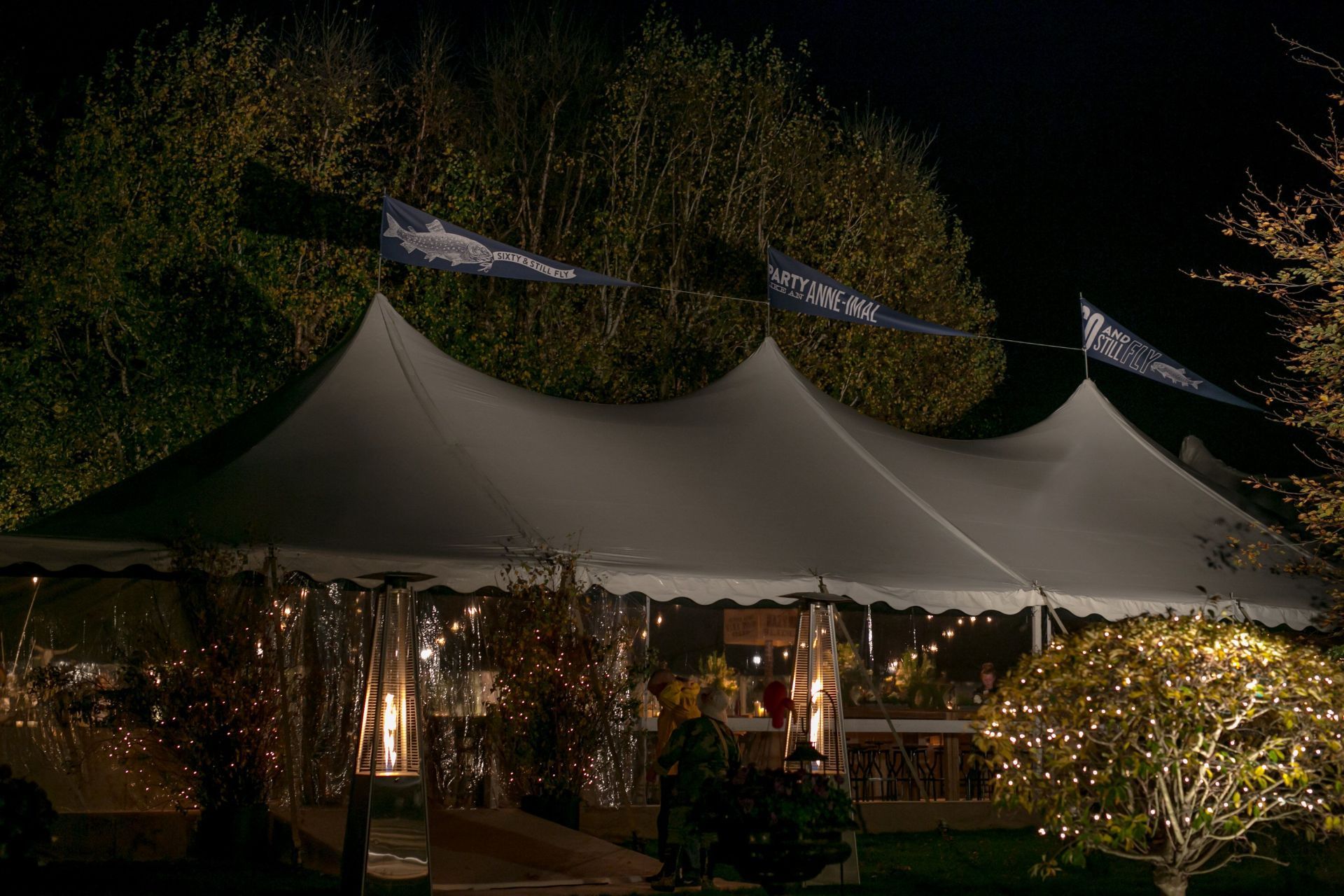 A large white tent is lit up at night.