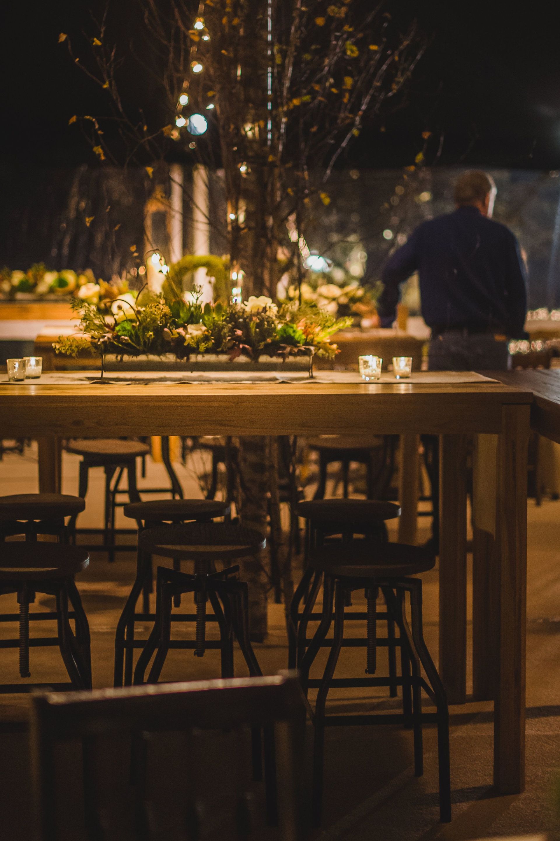 A man is standing in front of a table with flowers on it.