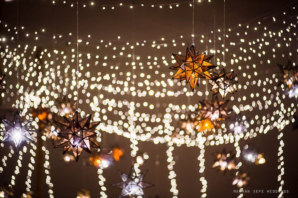 A bunch of christmas lights are hanging from the ceiling.