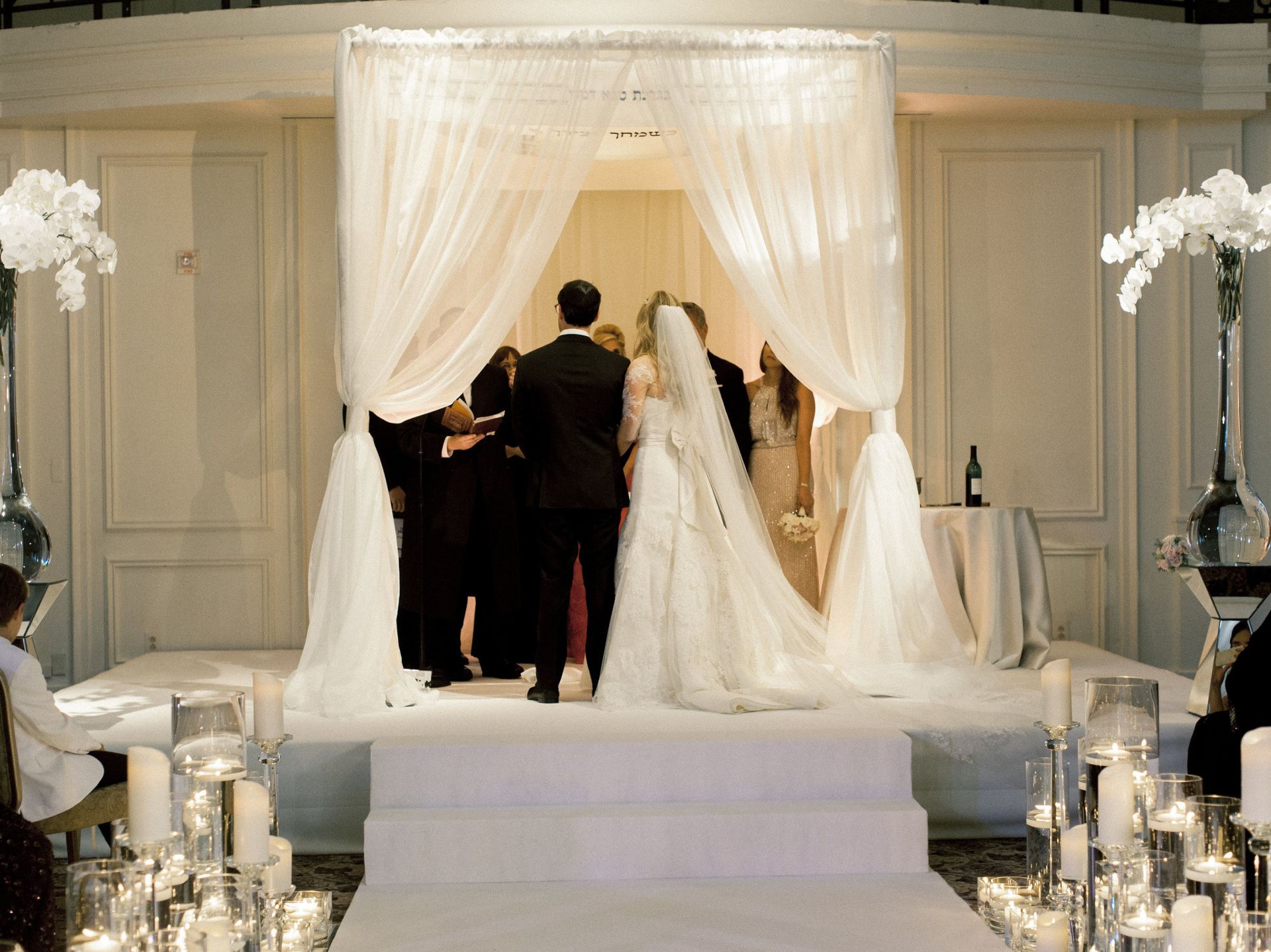 A bride and groom are getting married under a white canopy