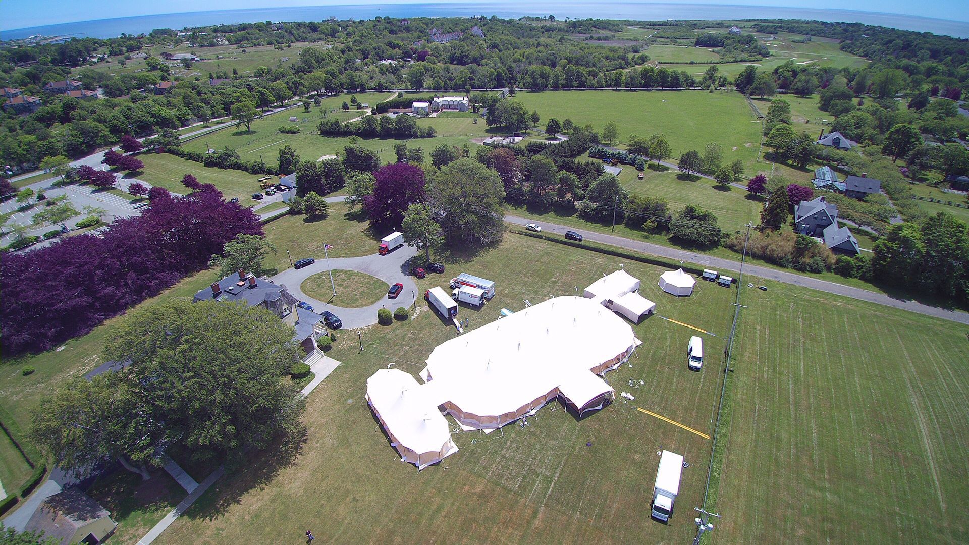 An aerial view of a large white tent in a field.
