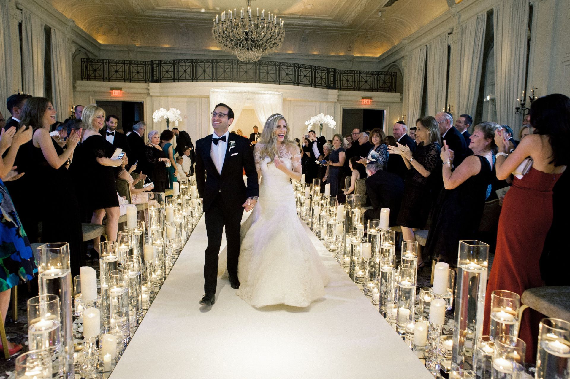 A bride and groom are walking down the aisle at their wedding.