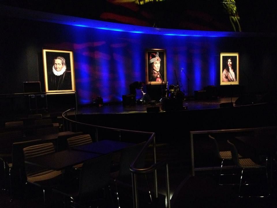 A dark room with a few paintings on the wall