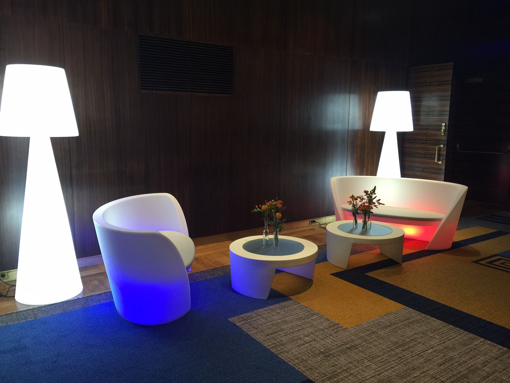 A living room with a couch , chairs , tables and lamps