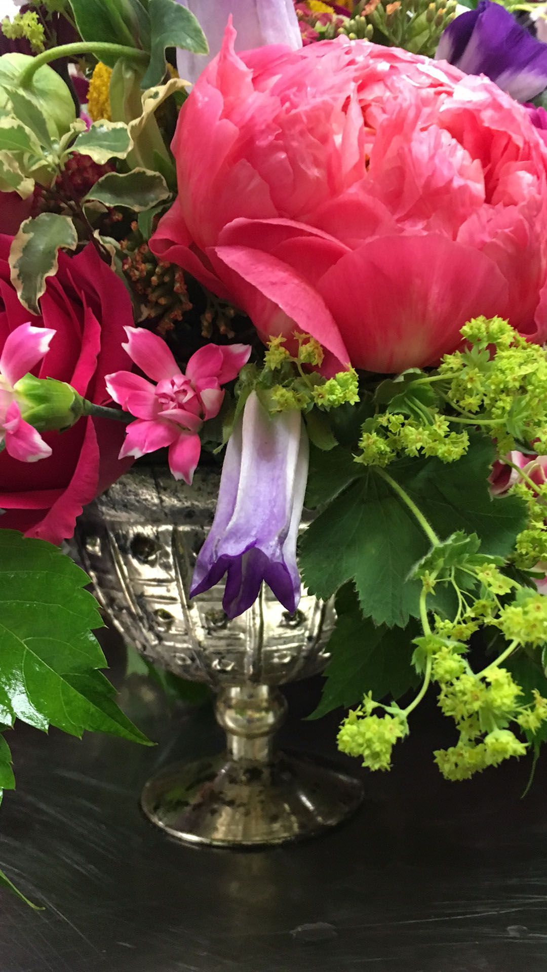 A close up of a vase filled with flowers on a table.