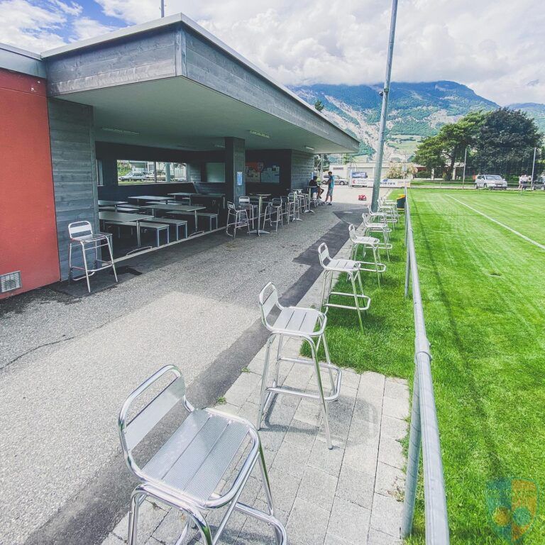 Une rangée de chaises et de tables à l'extérieur d'un bâtiment
