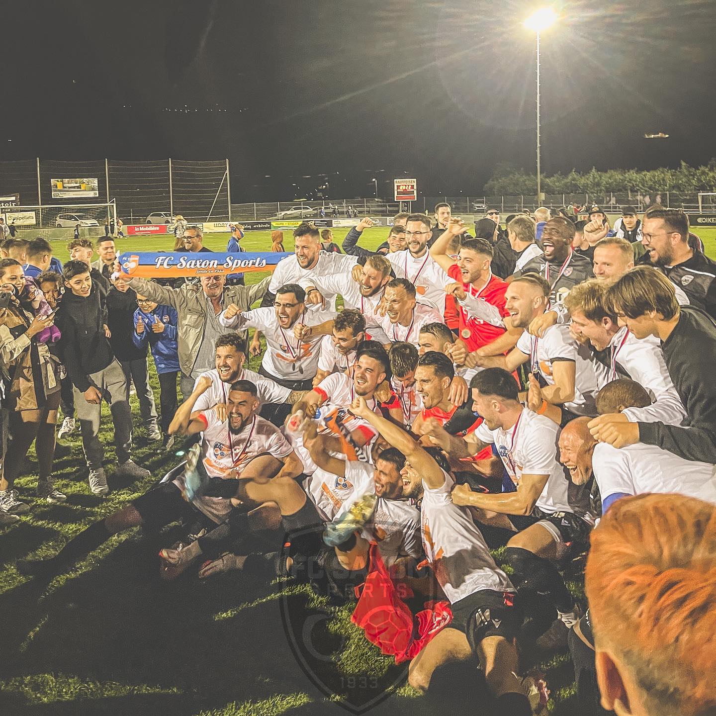 Un groupe de joueurs de football posent pour une photo sur un terrain
