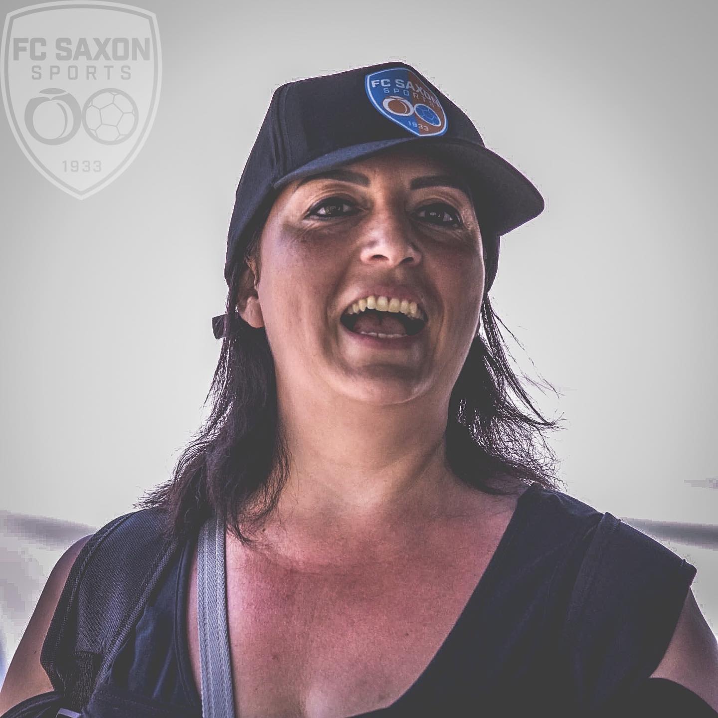 Une femme portant un chapeau sur lequel est écrit fc saxon sports