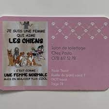 Une carte de visite rose avec une photo de chiens dessus.