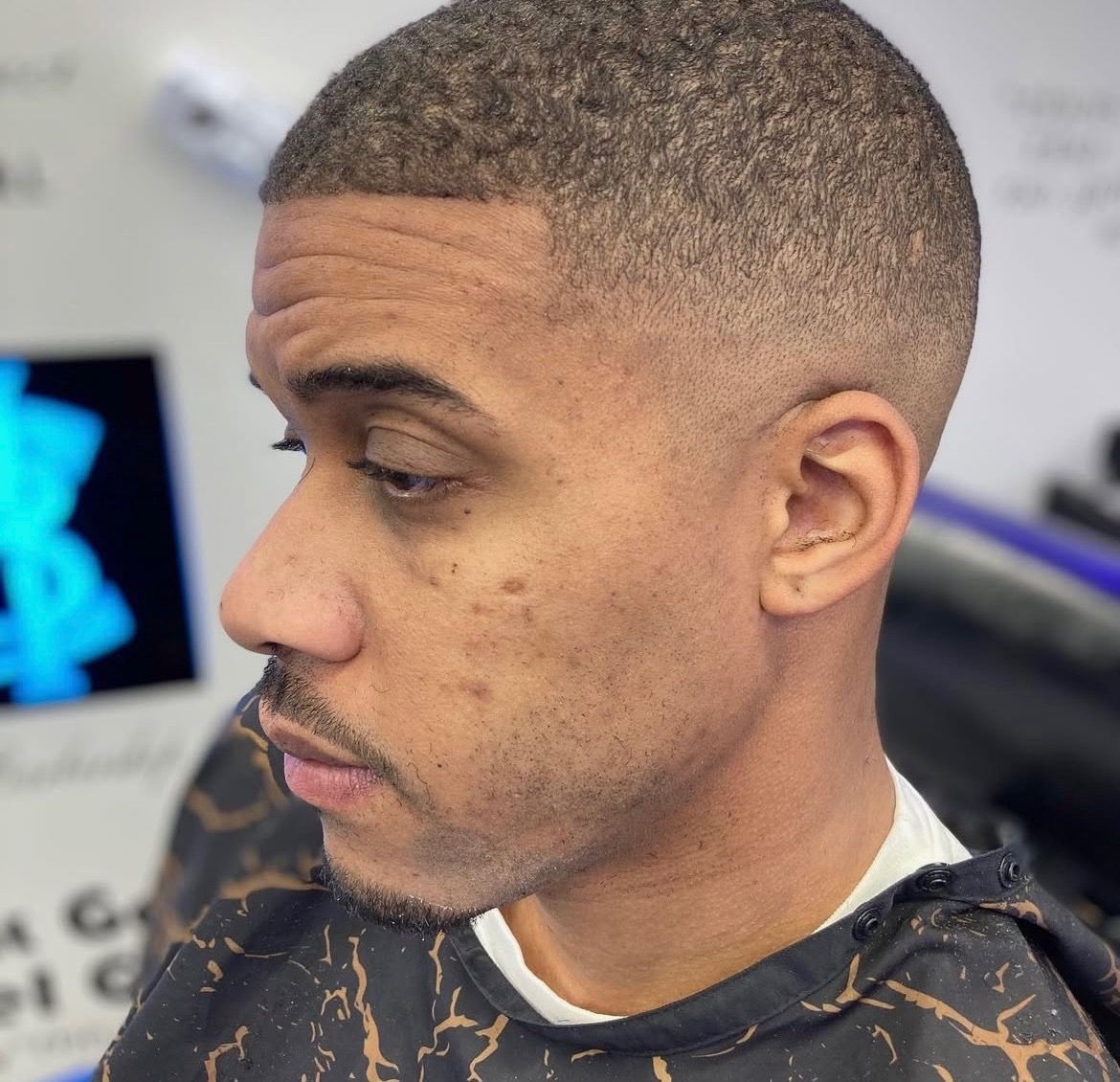 A man with a beard is getting his hair cut by a barber