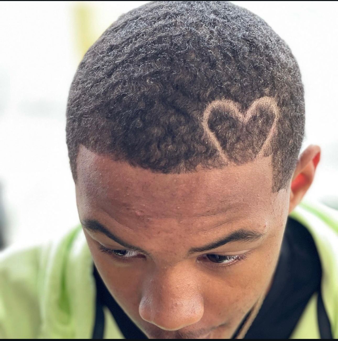 A young man has a heart carved into his hair