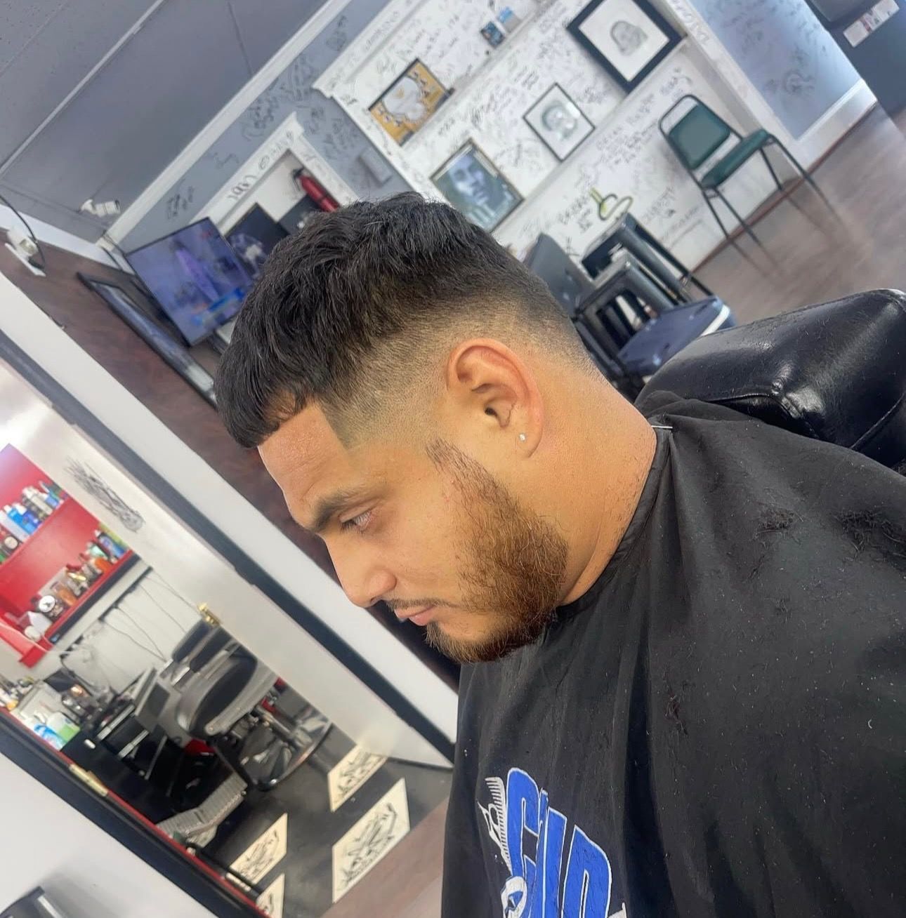 A man is getting his hair cut at a barber shop