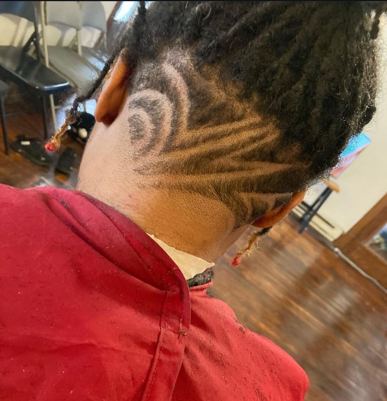 The back of a person 's head with a shaved design on it.