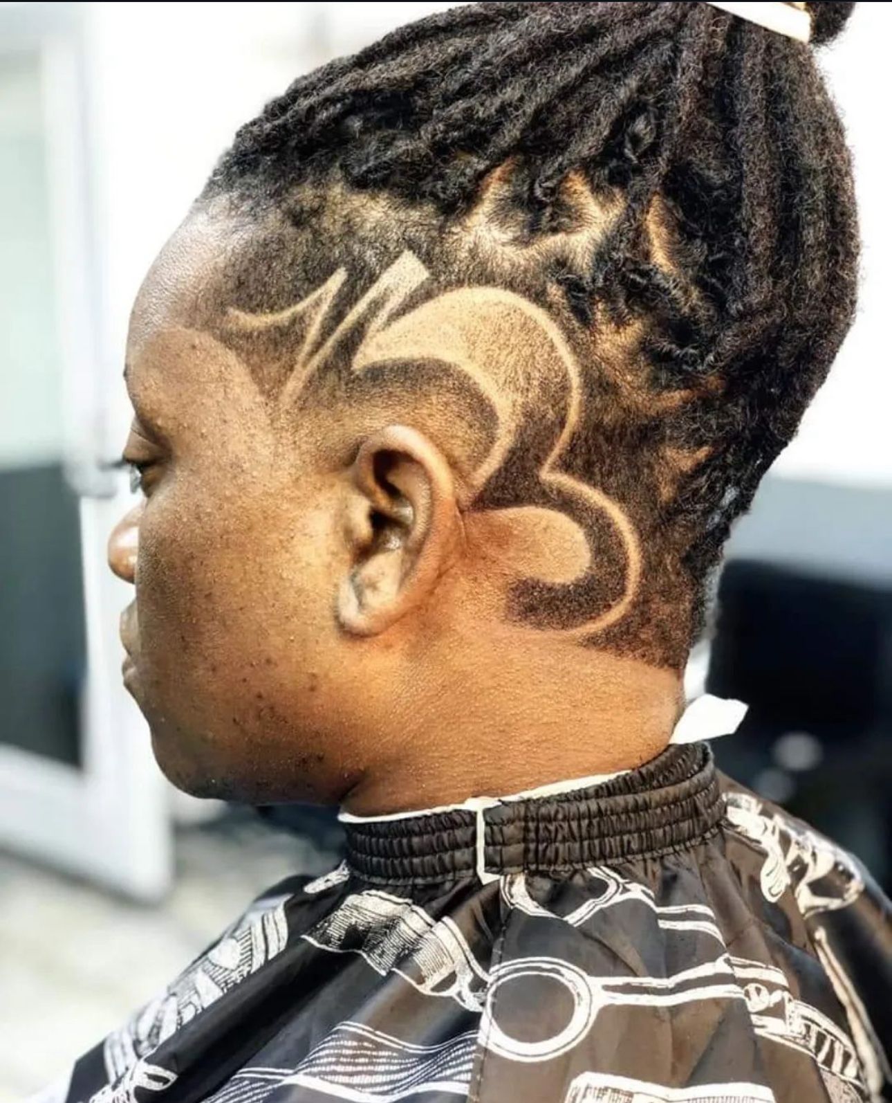 A woman with dreadlocks has a tattoo on her head.