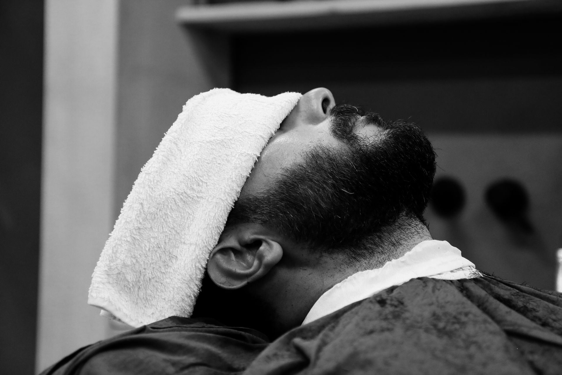 A black and white photo of a man with a towel on his head.