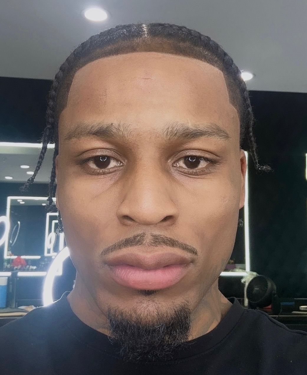 A close up of a man 's face with braids and a beard