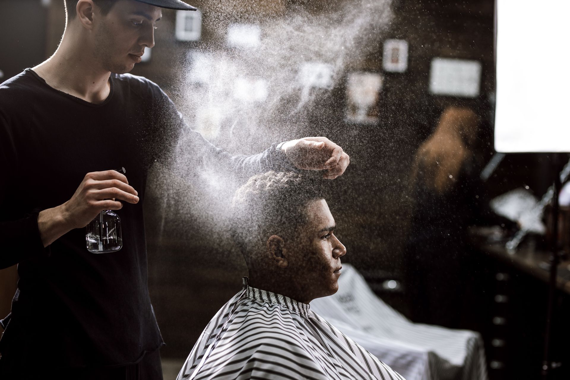 A man is getting his hair cut by a barber in a barber shop.