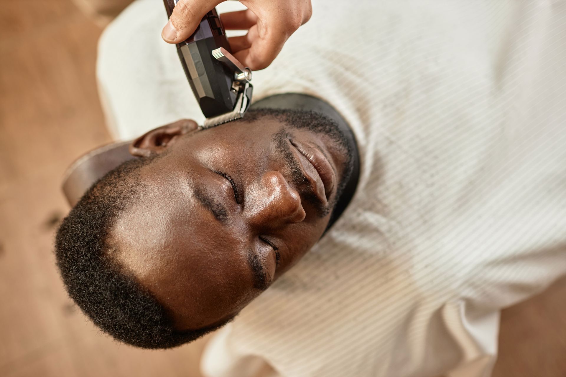 A man is getting his beard shaved by a barber.