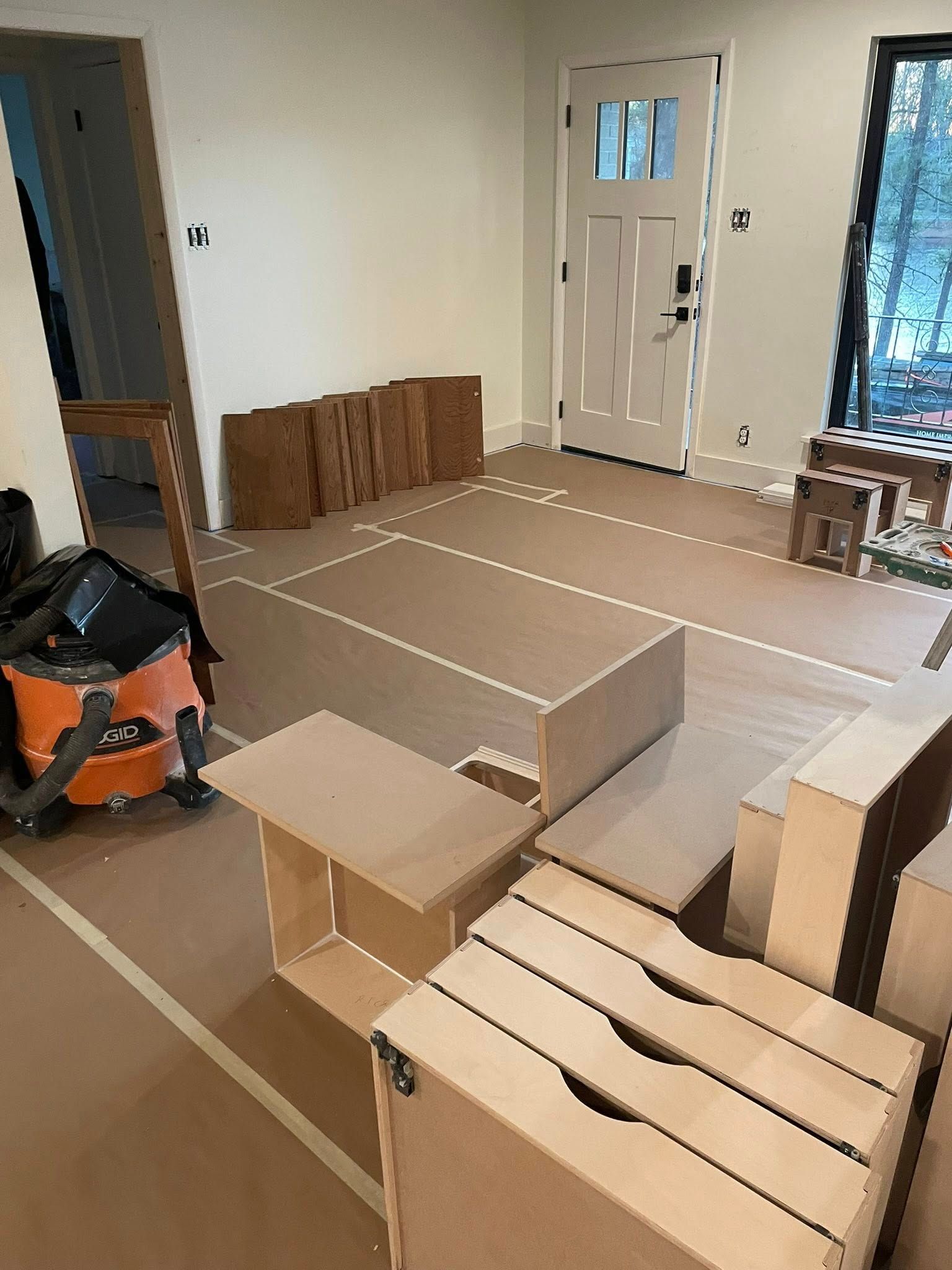 Interior room with unfinished cabinets and door, prepared for flooring.