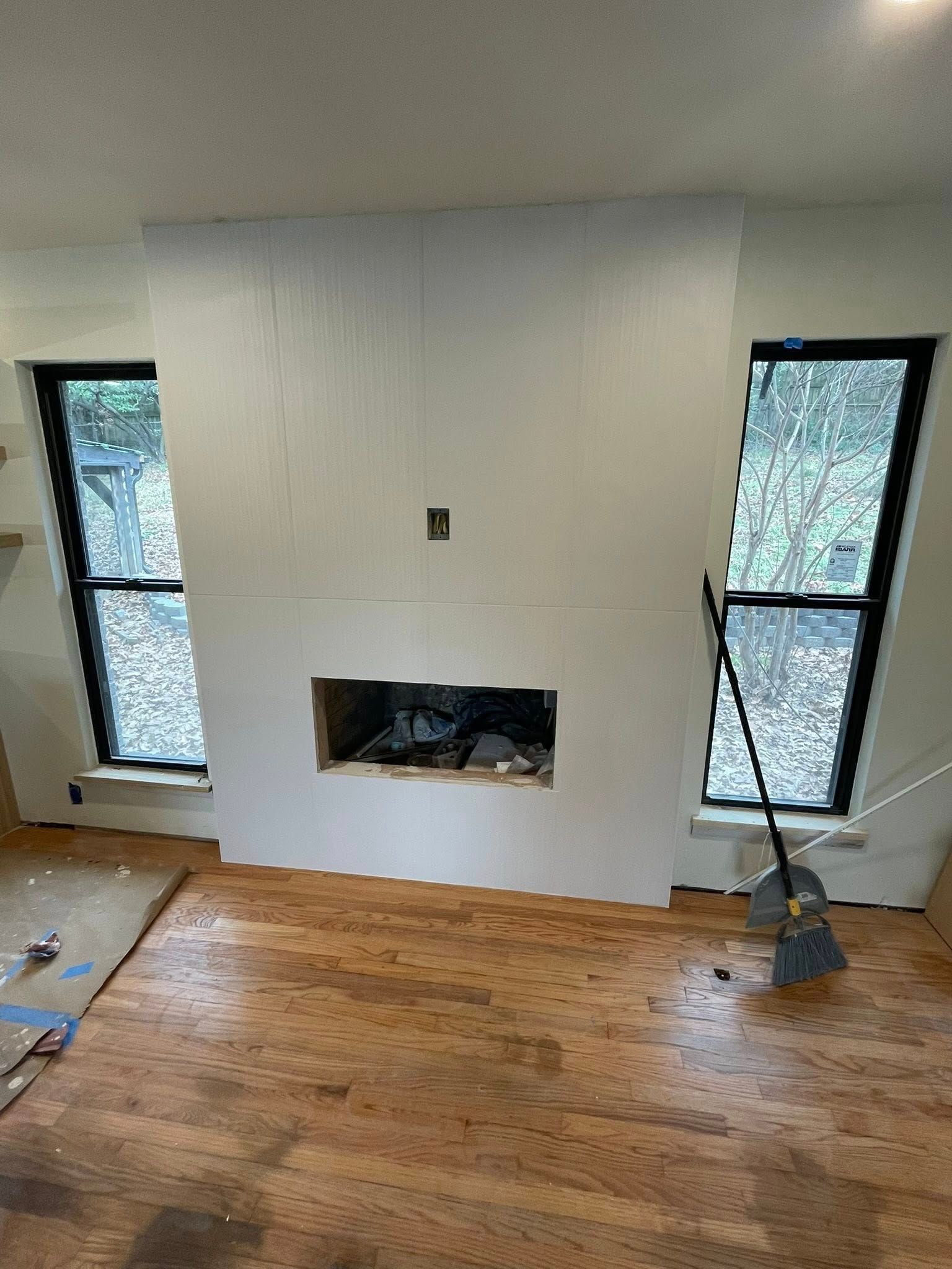 Fireplace with a built-in opening. Two windows flank the fireplace wall.
