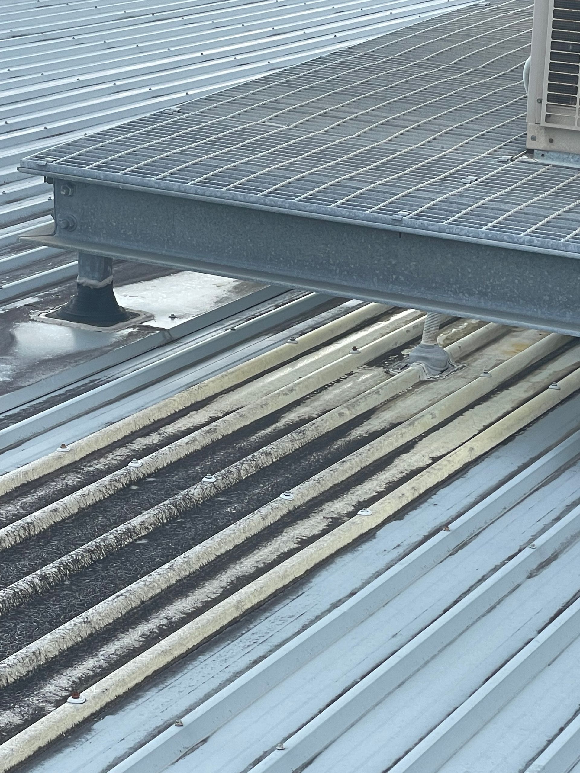 Stacked metal grating panels and corrugated sheets in an industrial storage area