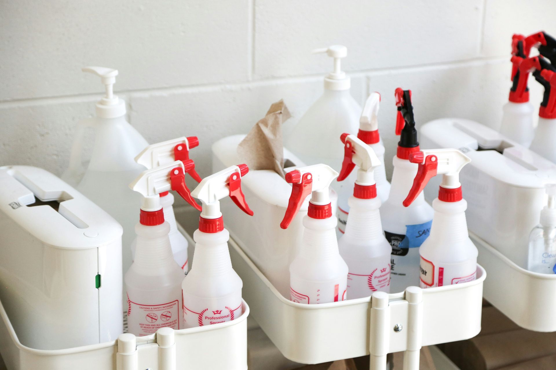 A bunch of spray bottles are sitting on a cart.
