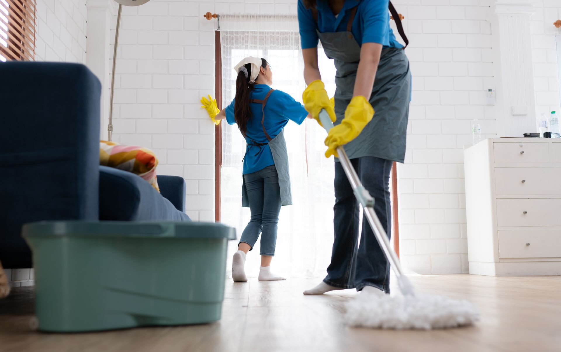 A woman and a child are cleaning the floor in a living room.