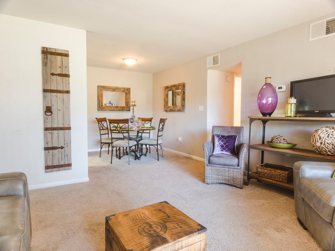 A living room with a couch , chair , table and television.