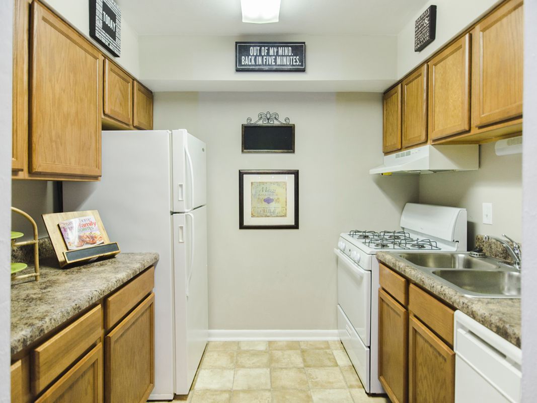 A kitchen with wooden cabinets and white appliances.