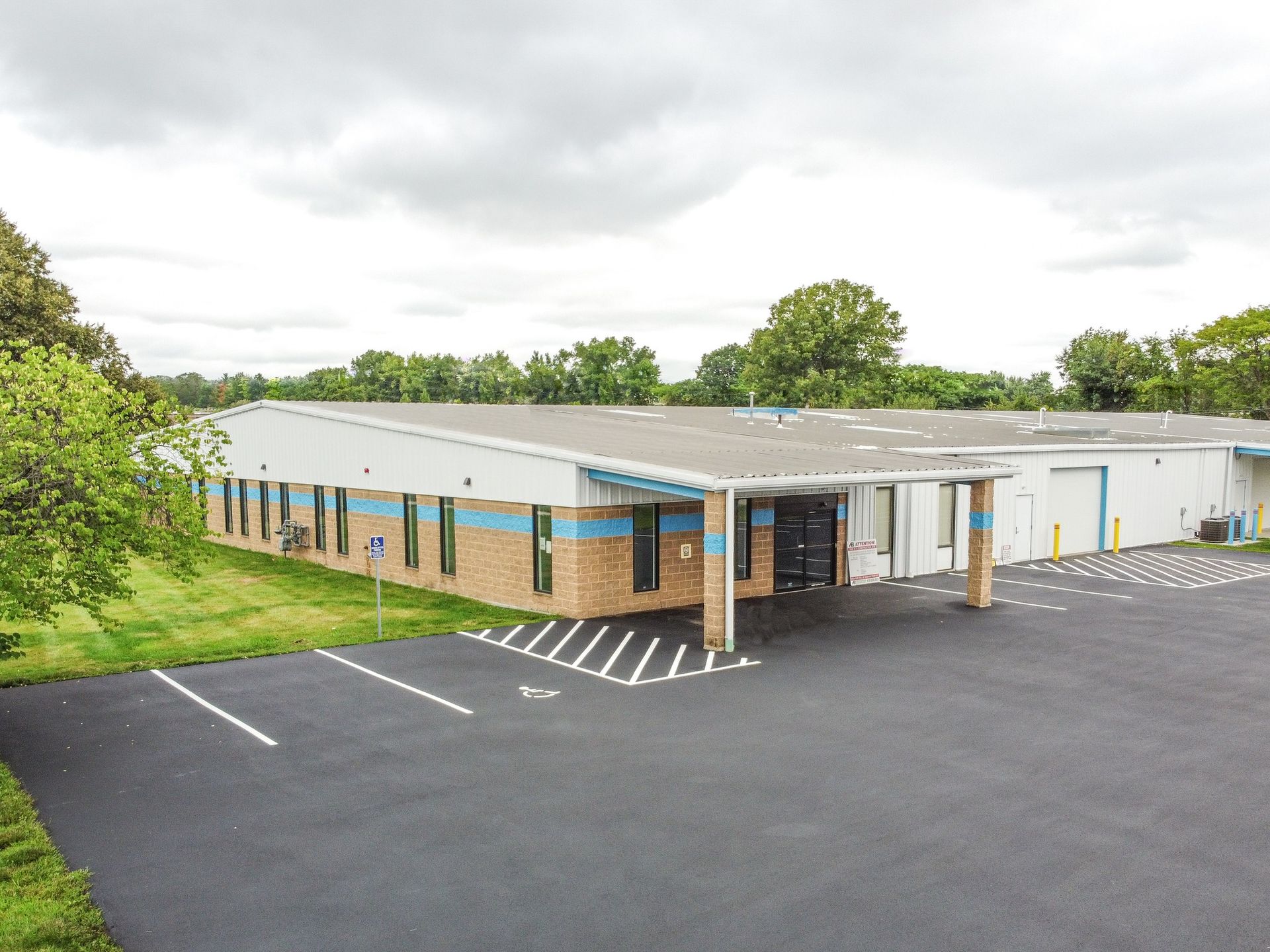 An aerial view of a large building with a parking lot in front of it.