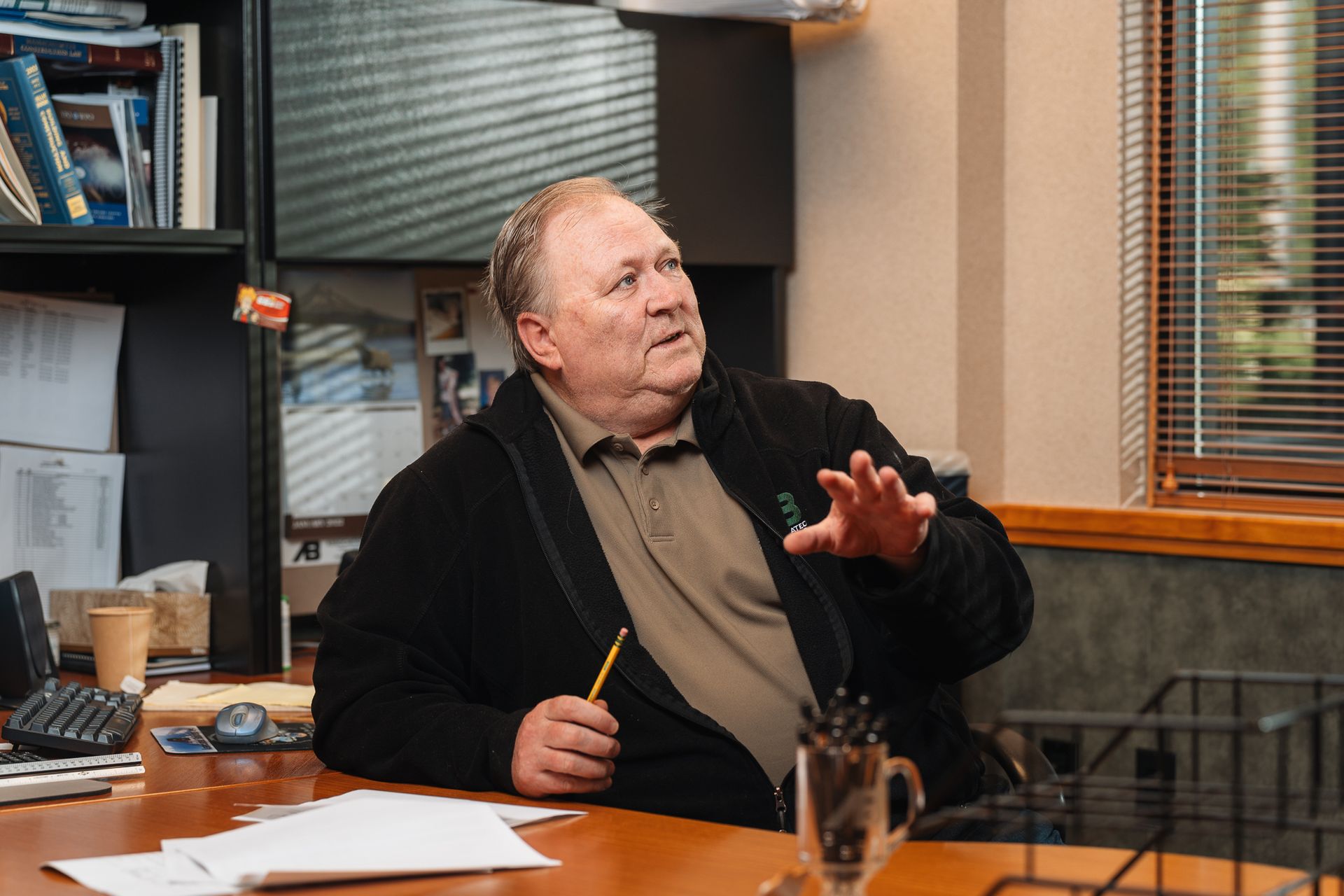 A man is sitting at a table with a pen in his hand.