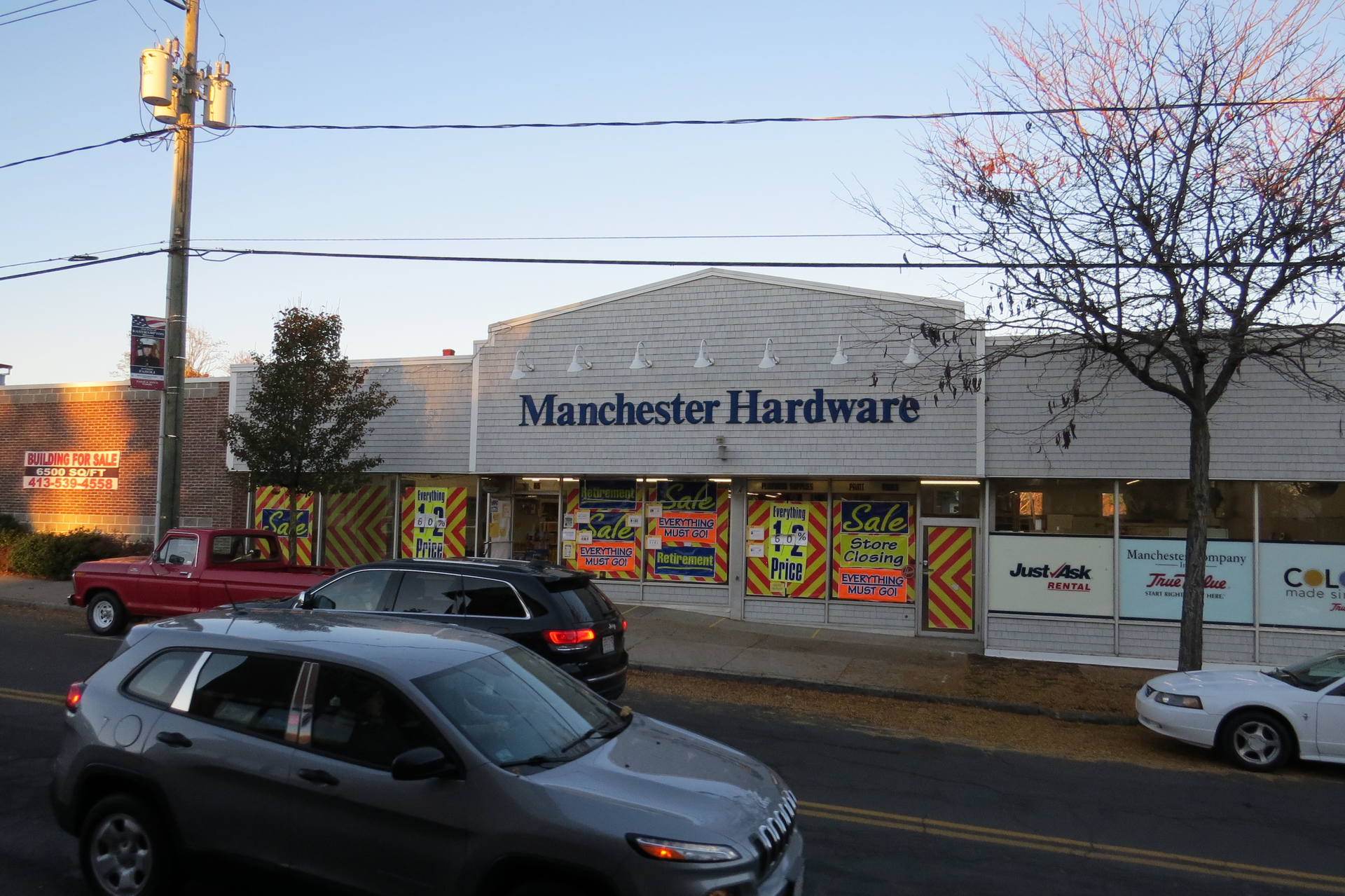 A manchester hardware store with cars parked in front of it