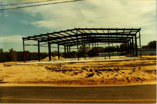 A large metal structure is being built in the middle of a dirt field