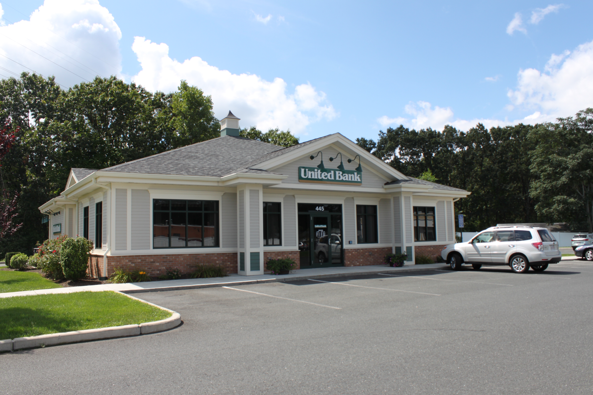 A united bank building with cars parked in front of it