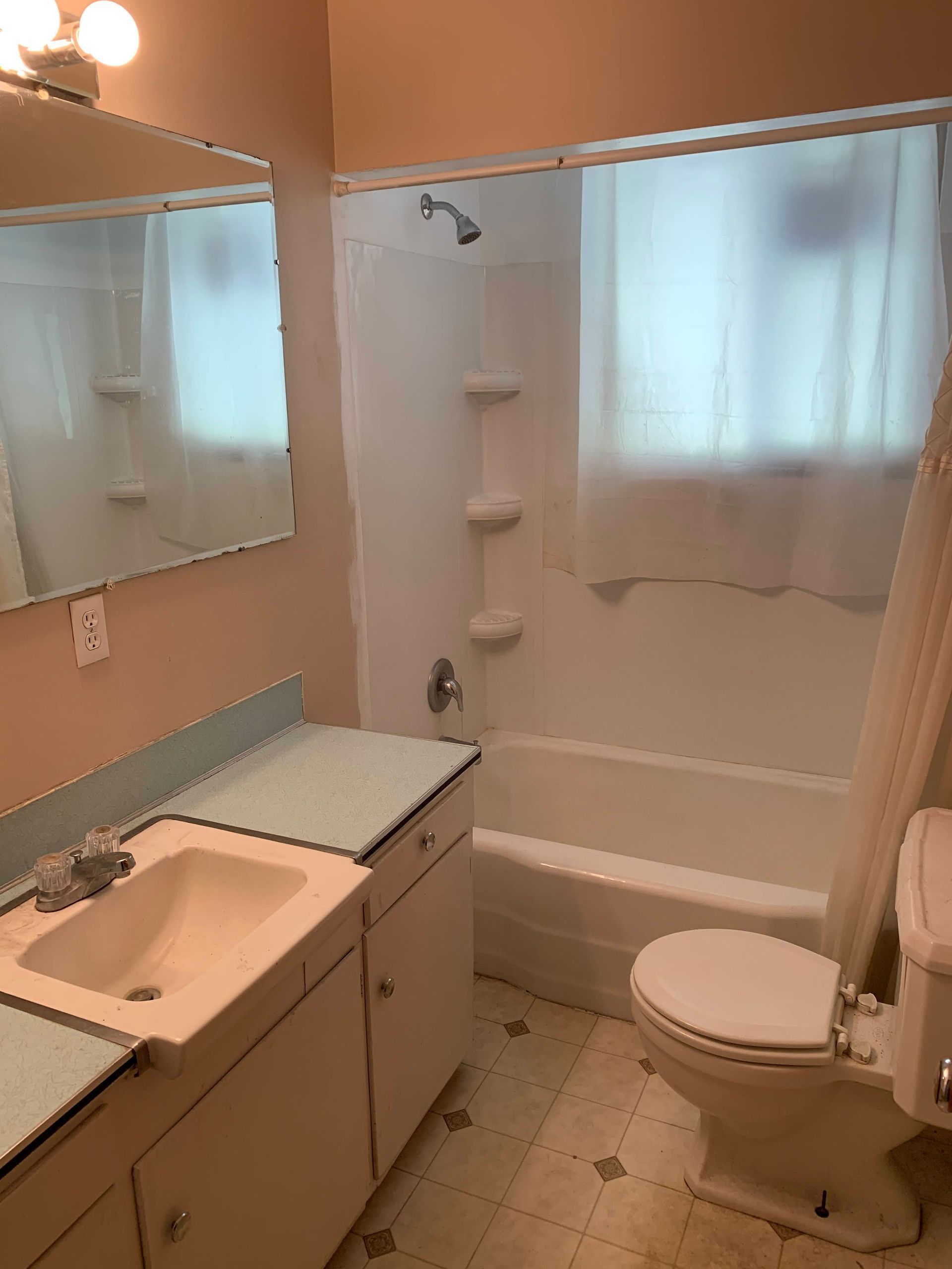 A bathroom with a toilet , sink , tub and shower.