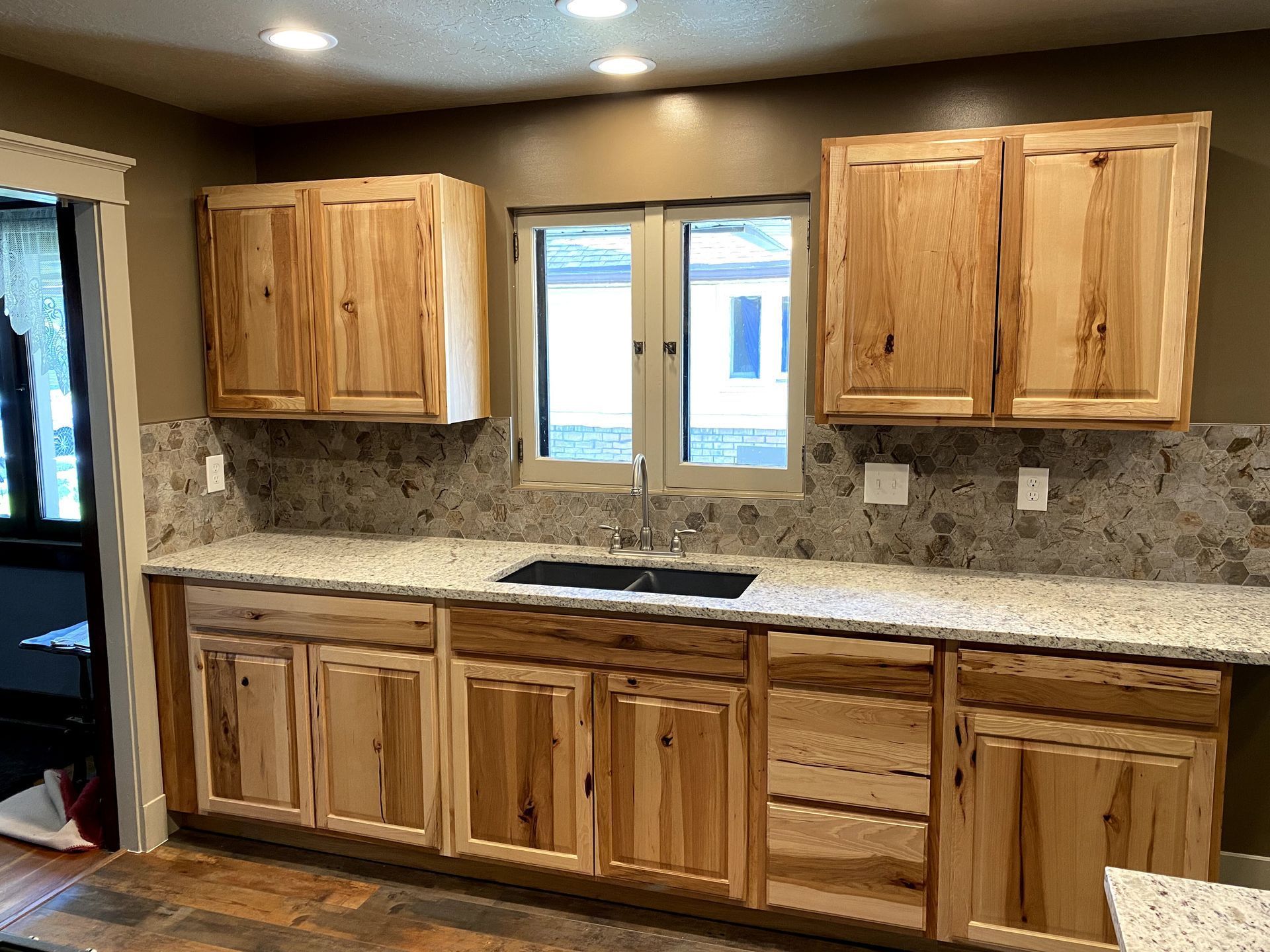 A kitchen with wooden cabinets and granite counter tops.