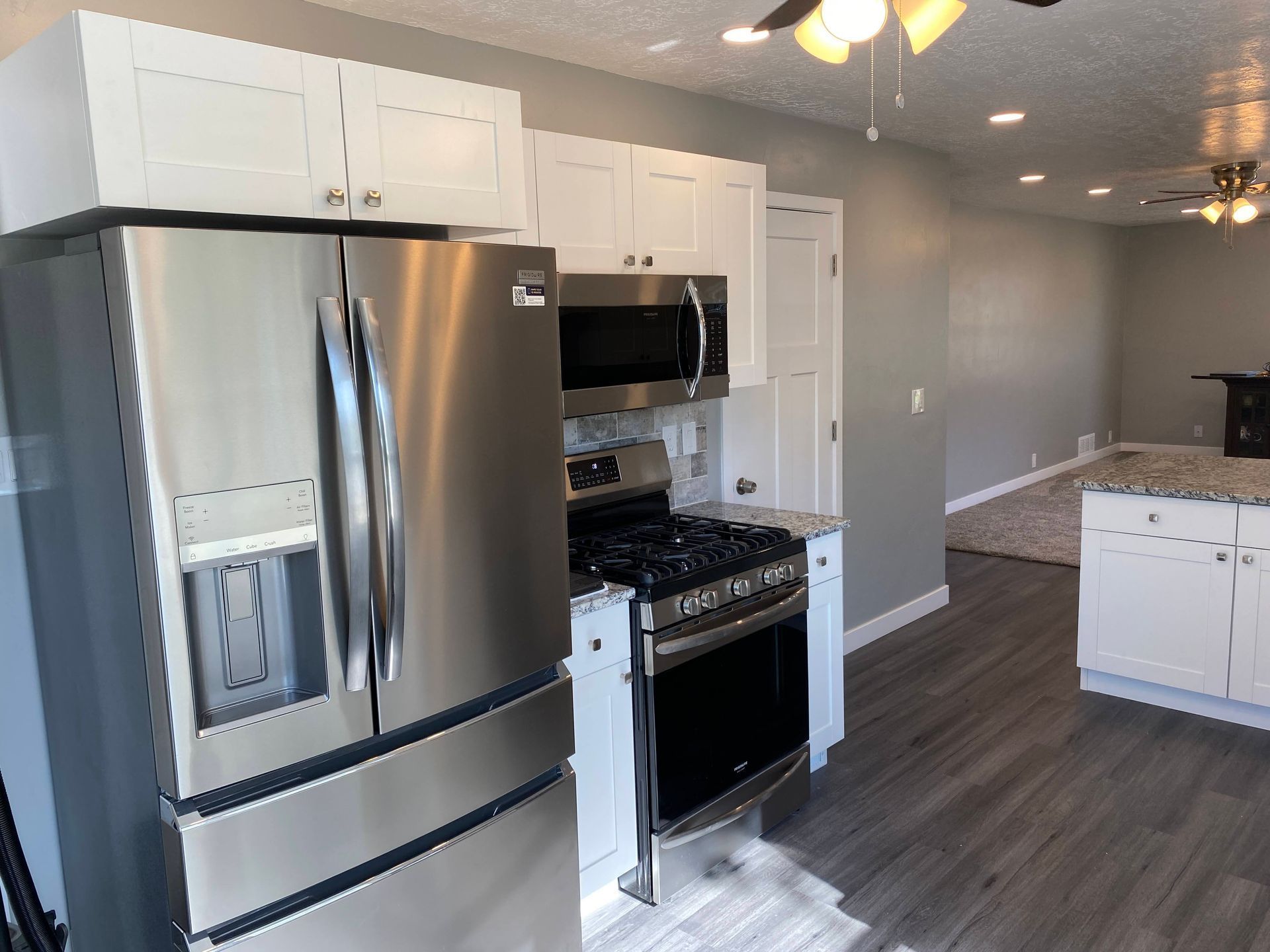 A kitchen with stainless steel appliances and white cabinets