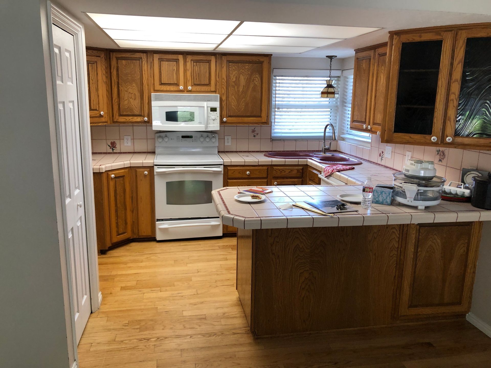 A kitchen with wooden cabinets , a stove and a microwave.