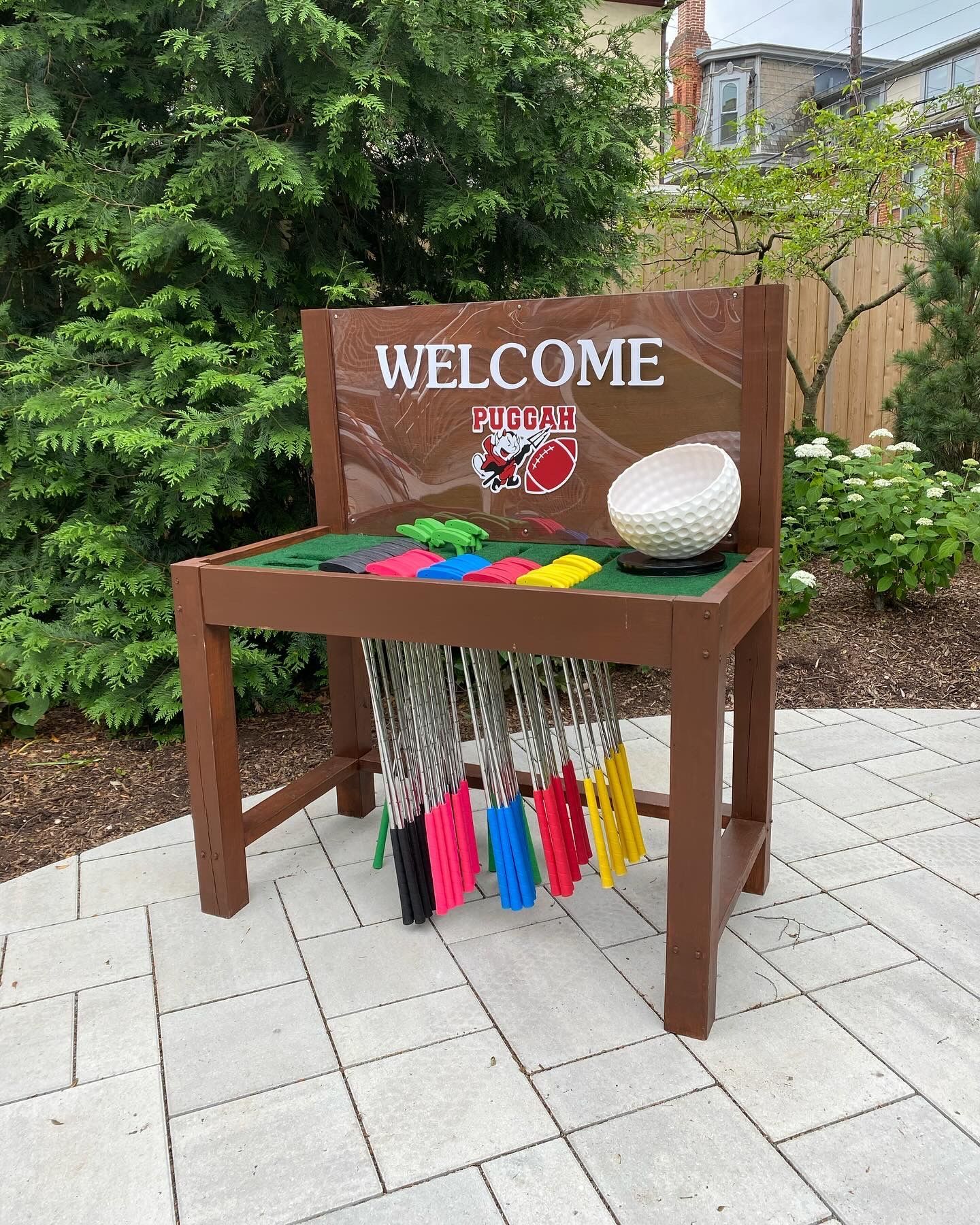 A wooden bench with a welcome sign on it.