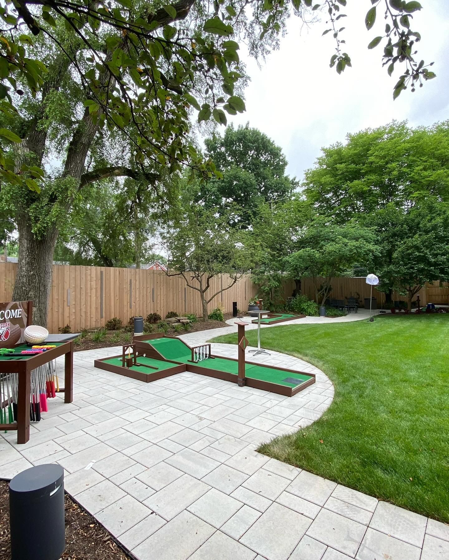 A backyard with a patio and a mini golf course.