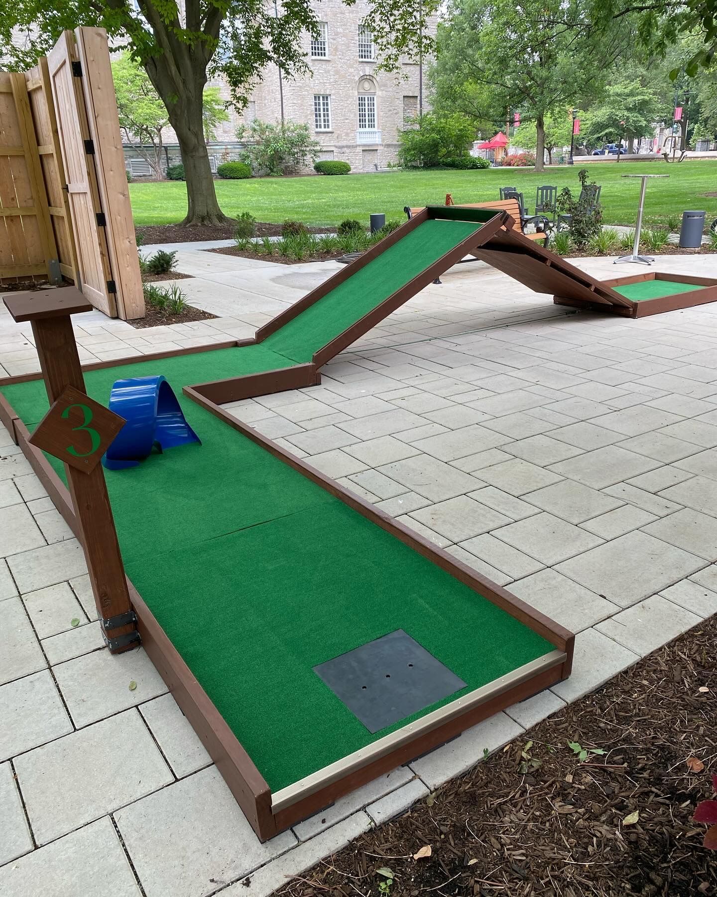 A mini golf course with a blue slide in the middle