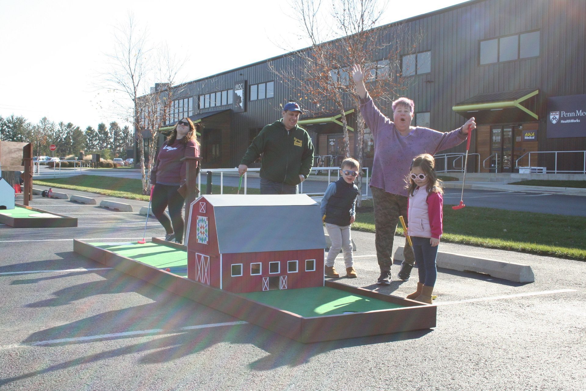 A group of people are standing in front of a mini golf course.