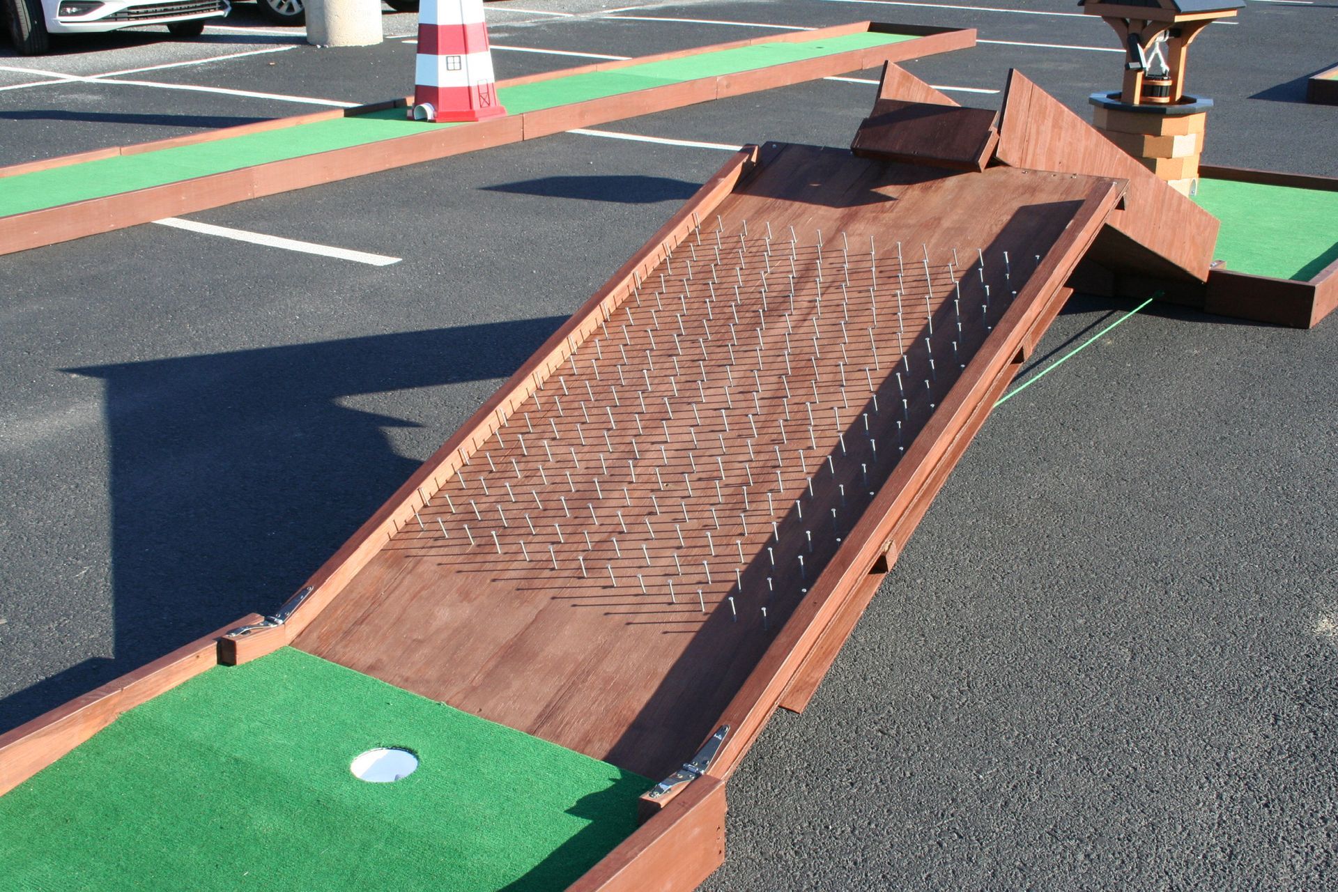 A wooden mini golf course in a parking lot