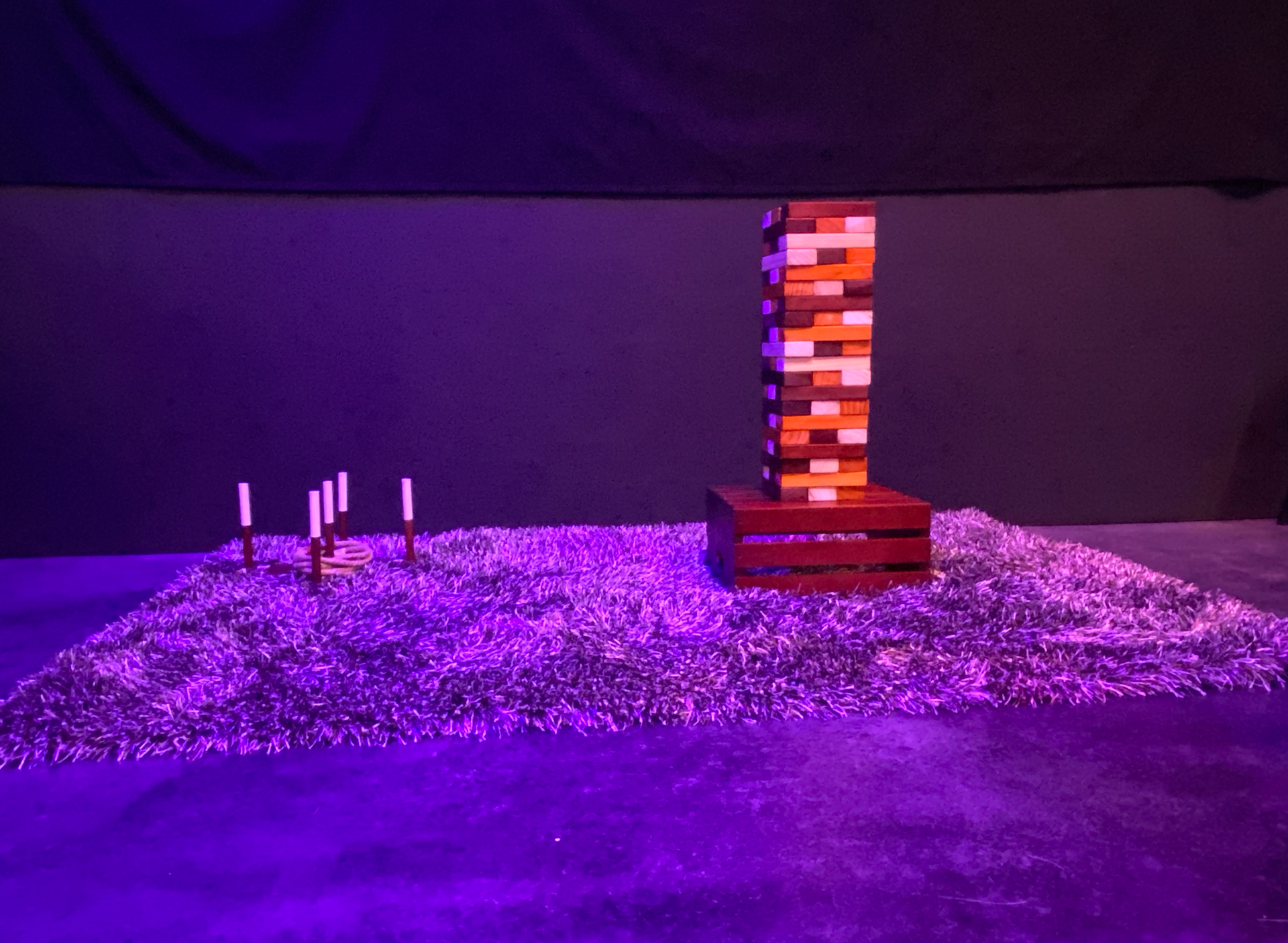 A purple carpet with candles on it and a tower in the background.