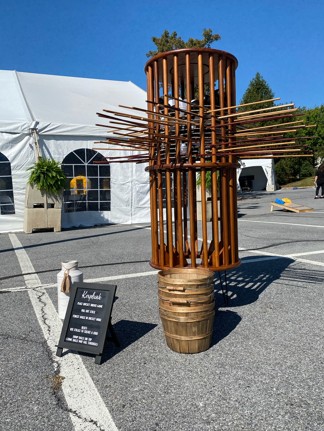 A wooden sculpture is sitting in a parking lot next to a sign.