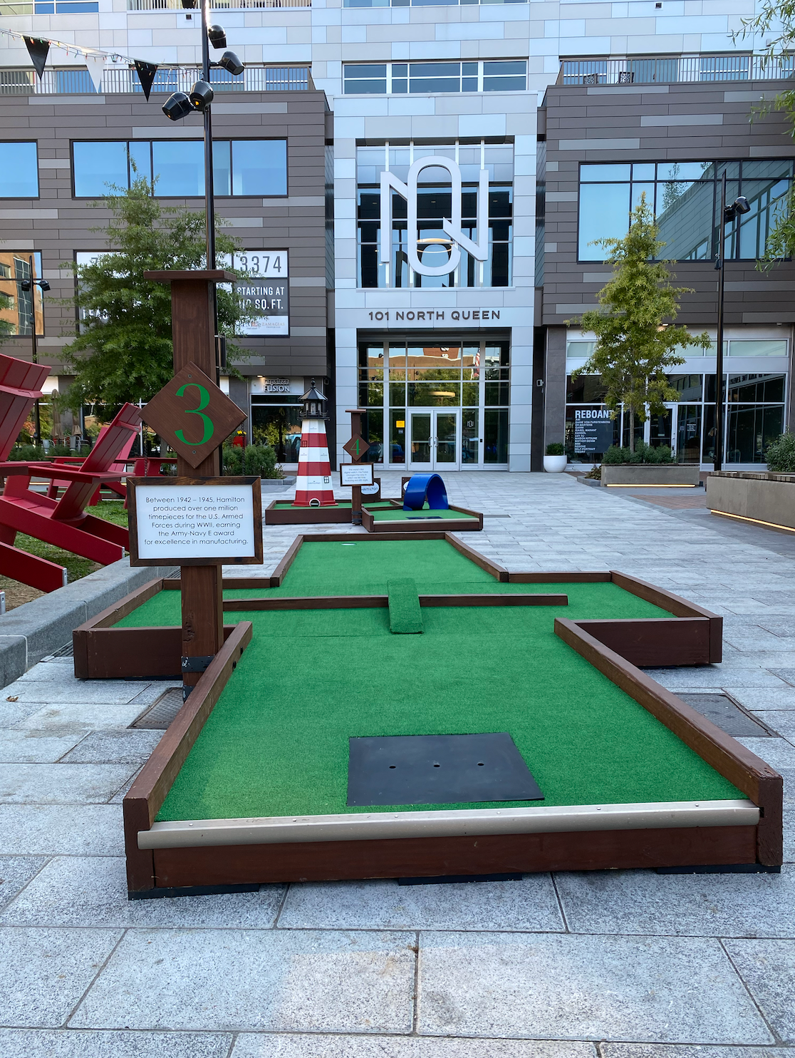 A mini golf course is sitting in front of a building.