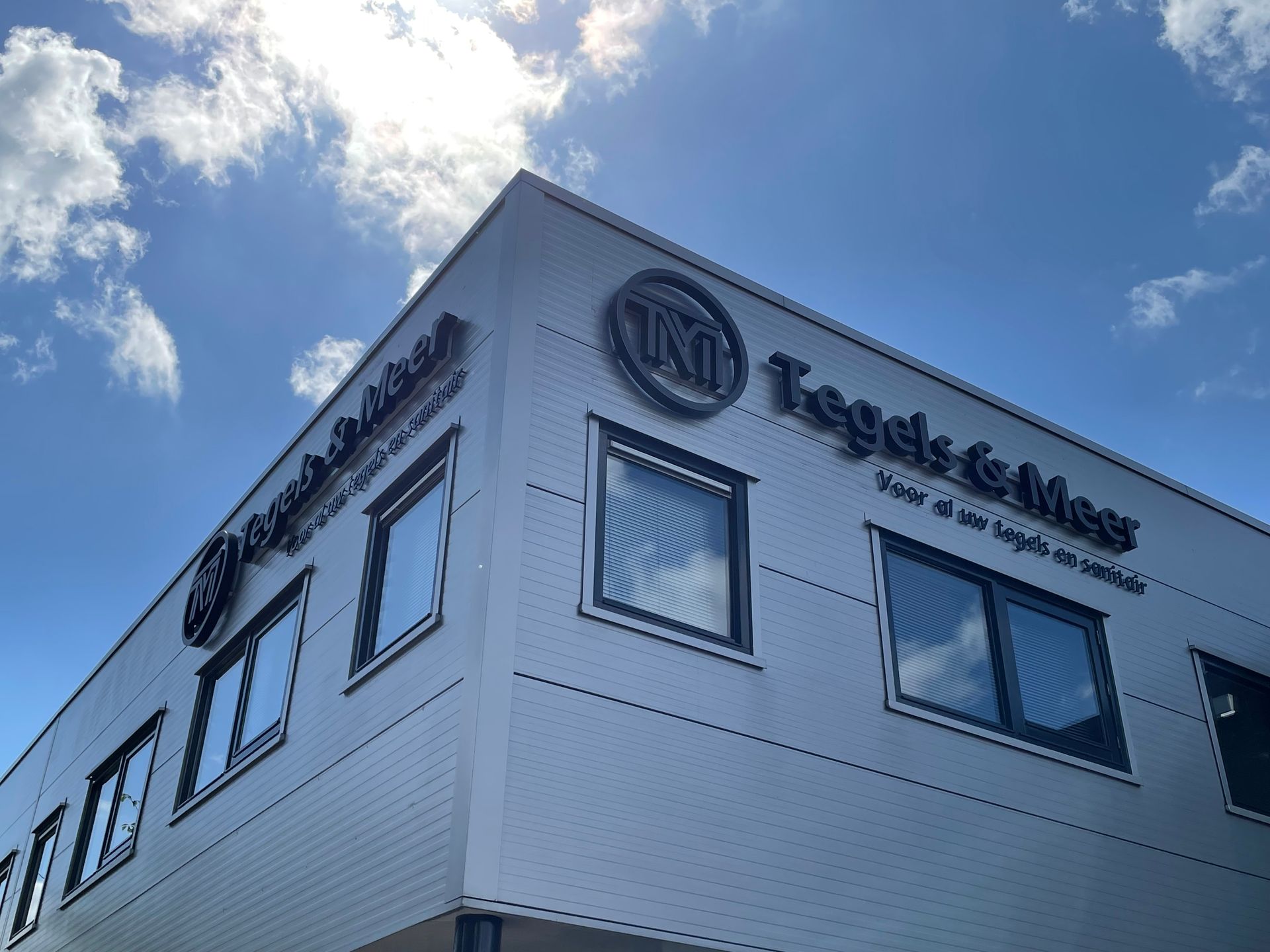  gevel van een wit, modern gebouw met het bord 